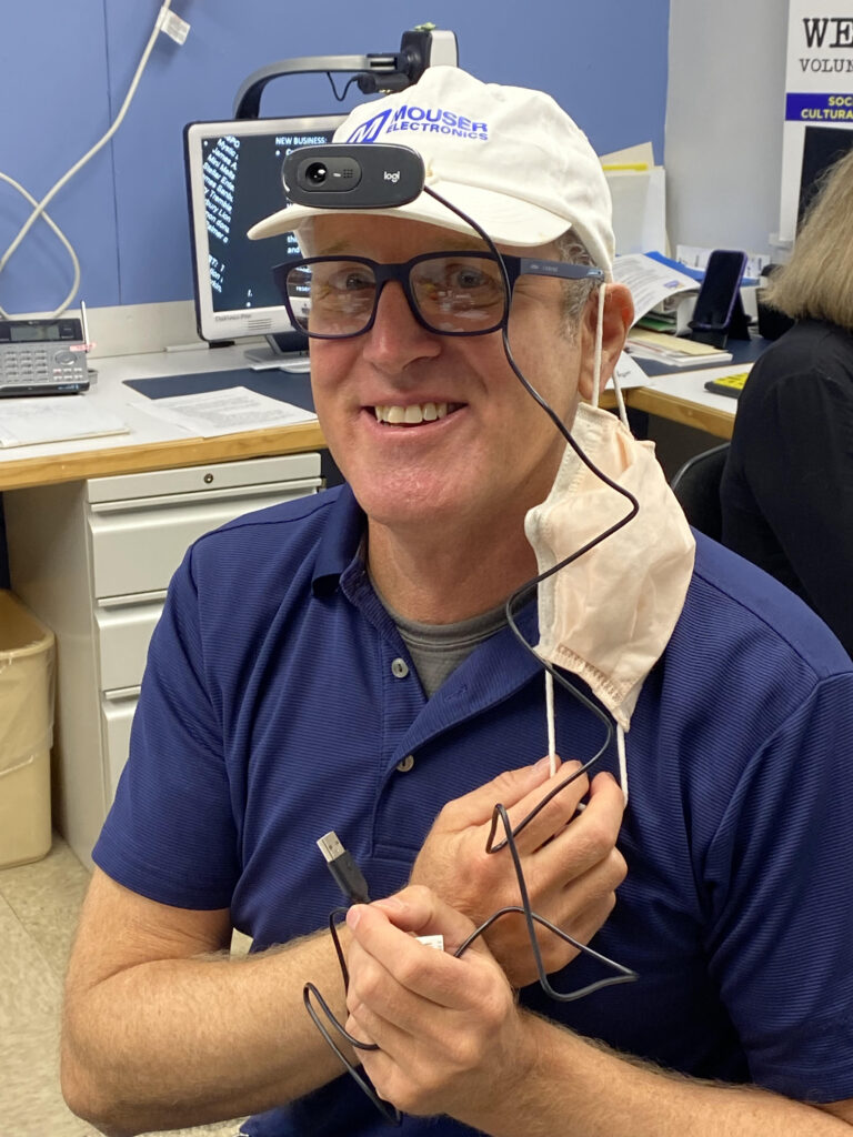 David Holmes wearing his hat that has a motion-activated camera on it attached to his laptop.  